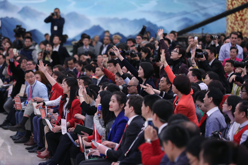 3月15日，國務院總理李克強在北京人民大會堂與中外記者見面，并回答記者提問。這是記者舉手爭取提問機會。 新華社記者 才揚 攝