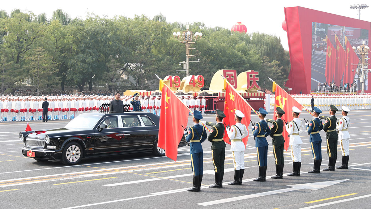 習(xí)近平驅(qū)車行進(jìn)至黨旗、國旗、軍旗前，向旗幟行注目禮